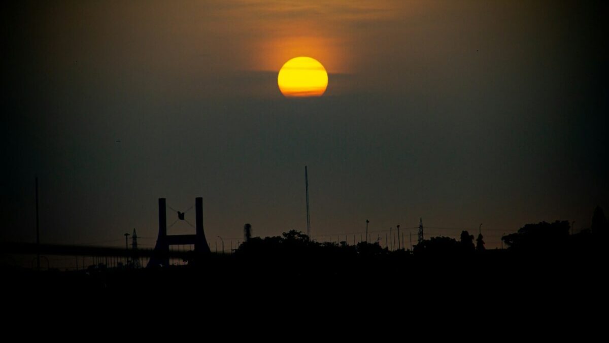 the sun is setting over the horizon of a city