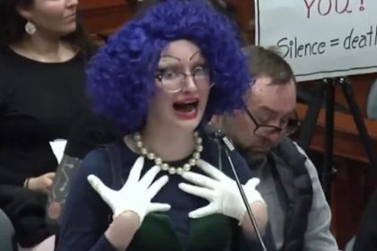 Lesbian pastor blasphemes Jesus as drag queen at council meeting