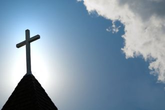 An old wood cross on a church steeple.
