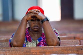 A woman prays at church in Minna, Nigeria, after a separate incident last year which saw scores of people kidnapped. The country has been rocked by sectarian violence in recent years. Pic: Reuters